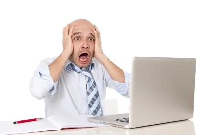 A man in a panic in front of a laptop